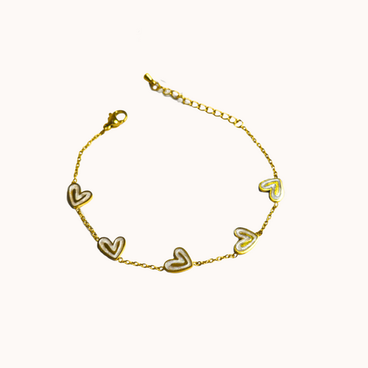 Gold bracelet with heart-shaped charms on a white background