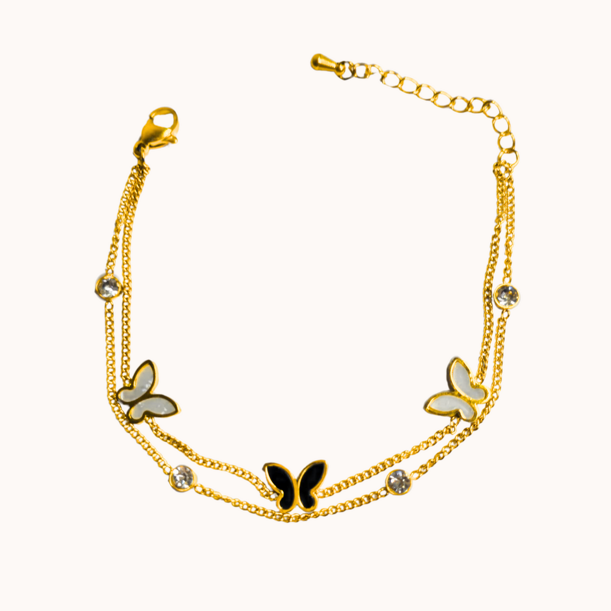 Gold bracelet with butterfly charms on a white background