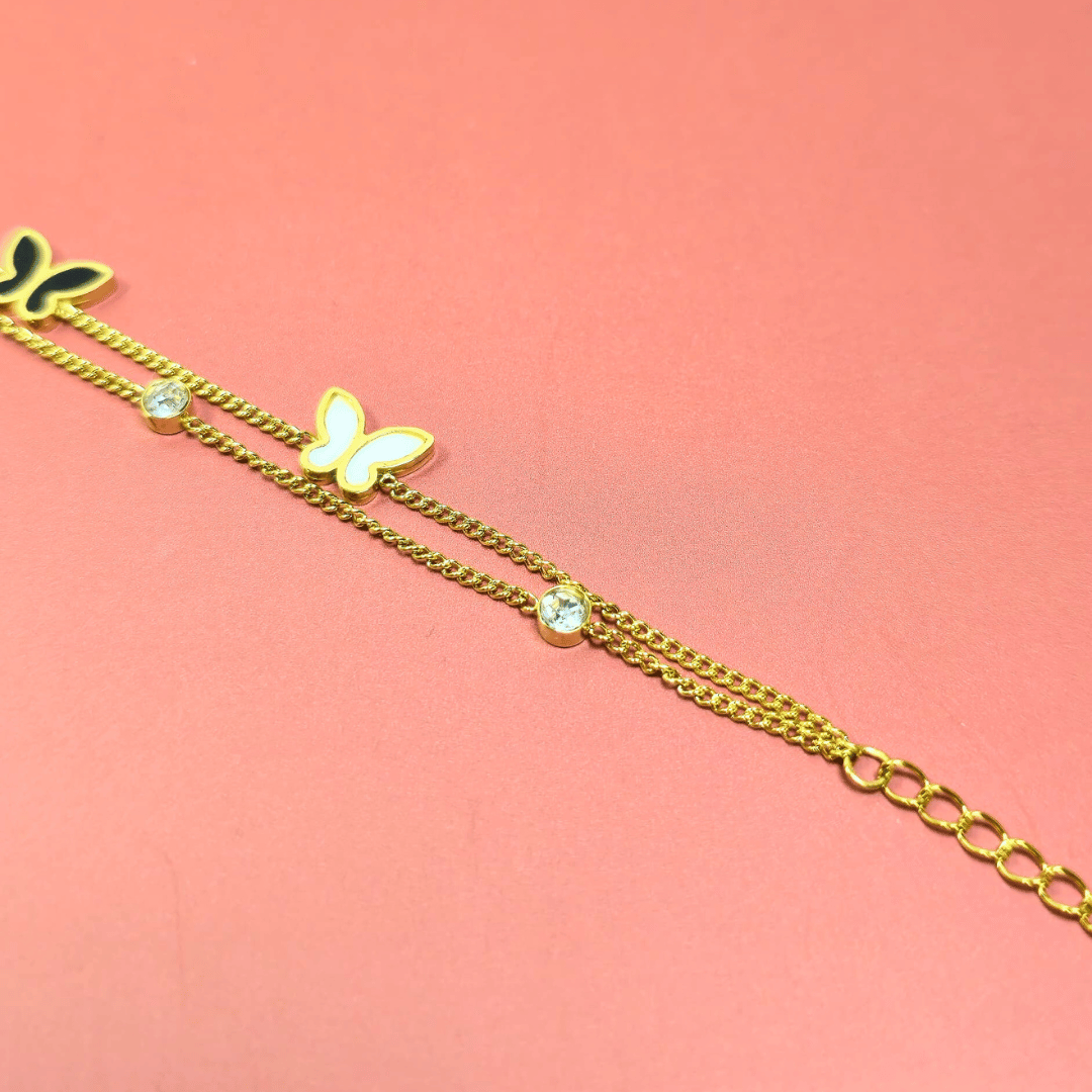 Gold bracelet with a butterfly charm on a pink background