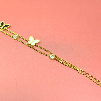 Gold bracelet with a butterfly charm on a pink background