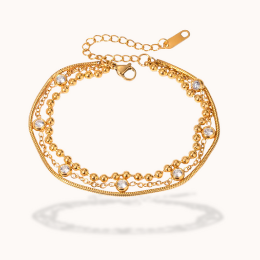 Gold bracelet with small crystals on a white background