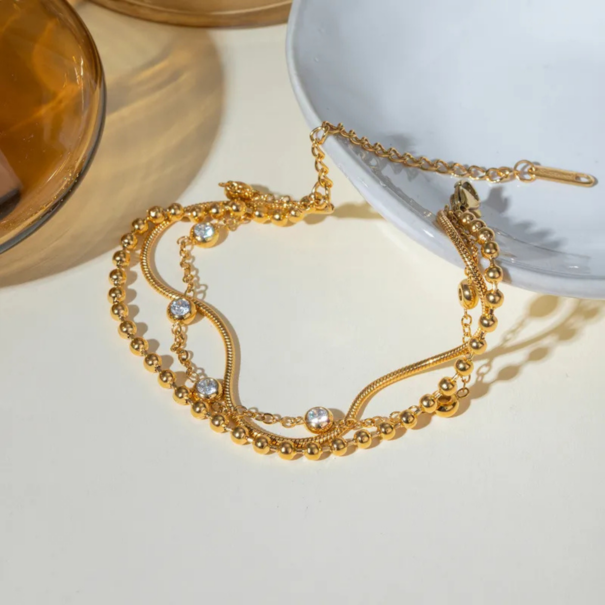 Gold necklace with beads and crystals on a light background