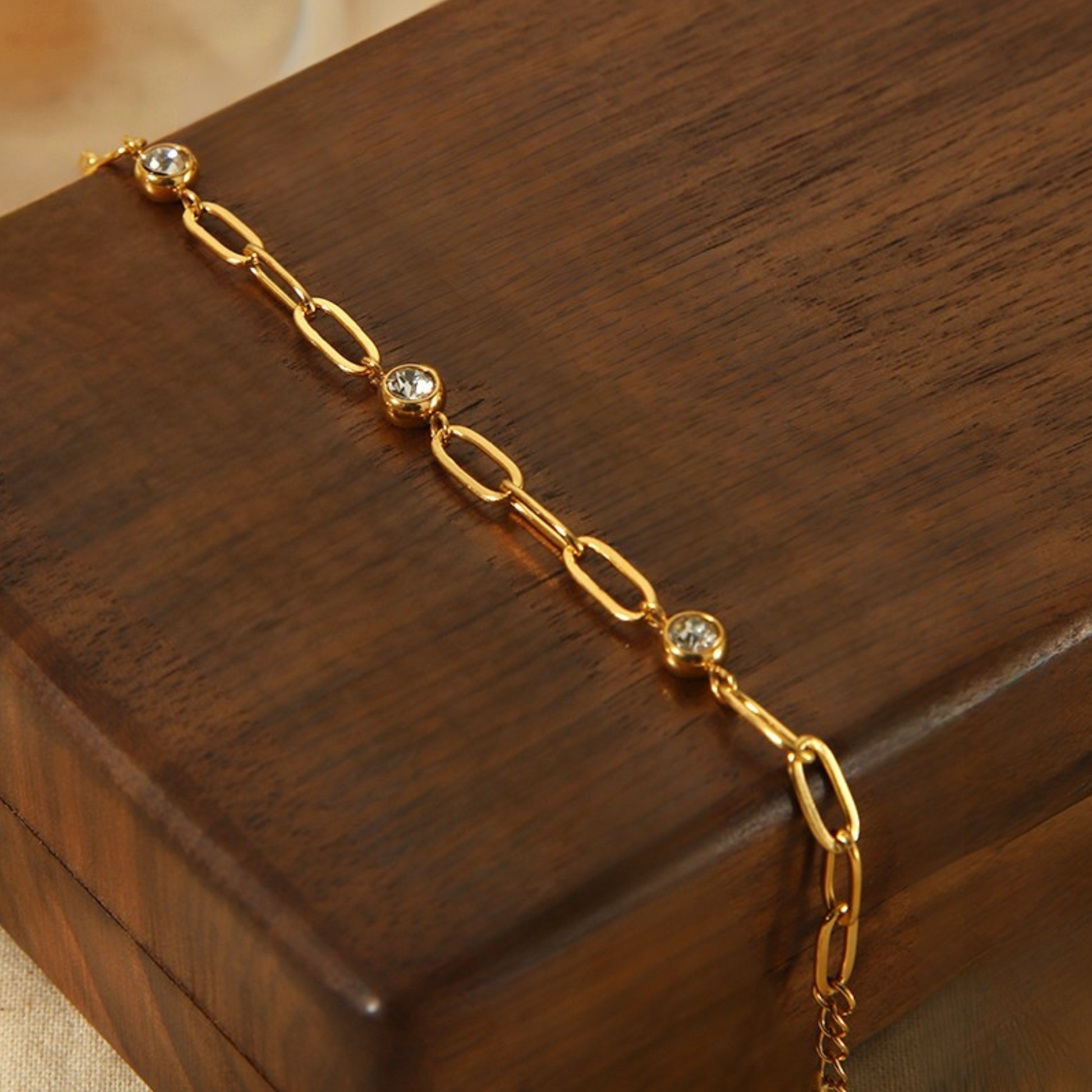 Gold bracelet with small diamonds on a wooden surface