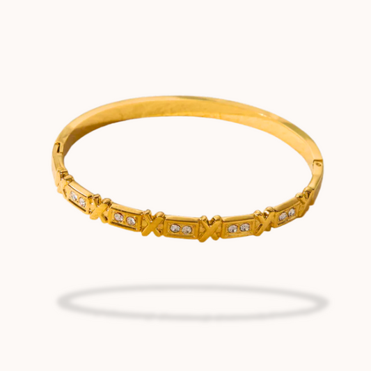 Gold bracelet with diamond accents on a white background