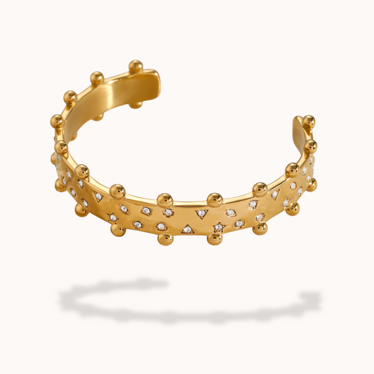 Gold bracelet with small diamonds on a white background