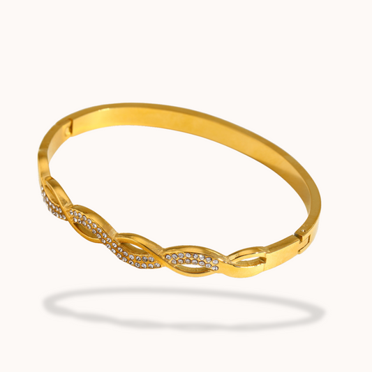 Gold bracelet with diamond accents on a white background