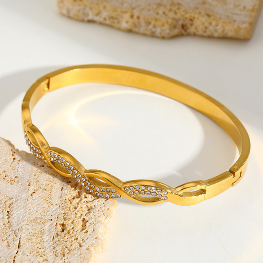 Gold bracelet with diamond accents on a light background