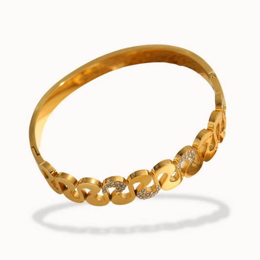 Gold bracelet with interlocking links on a white background