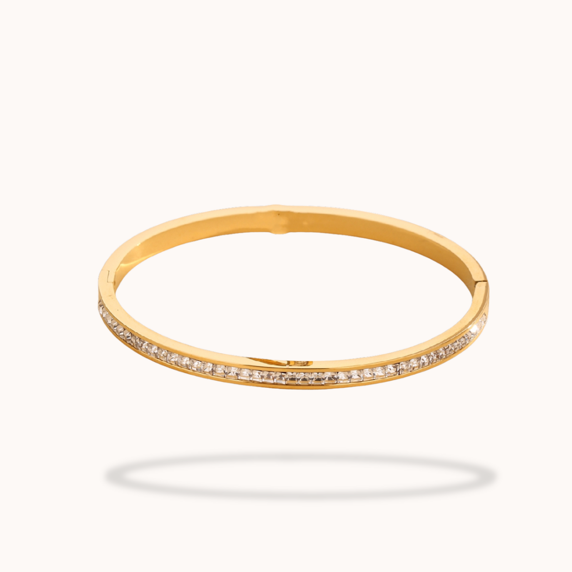 Gold bangle with small diamonds on a white background