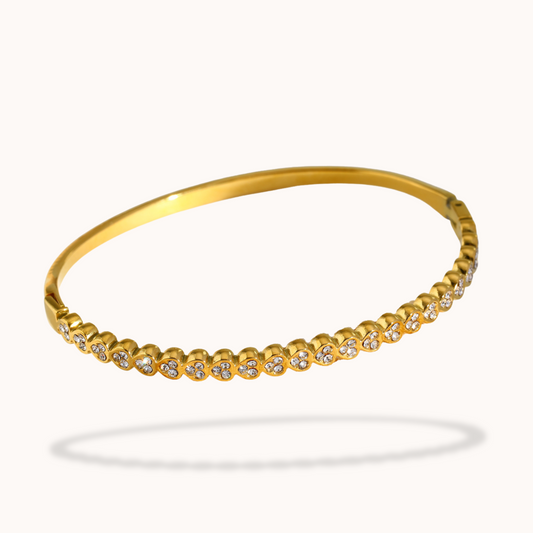 Gold bracelet with small diamonds on a white background