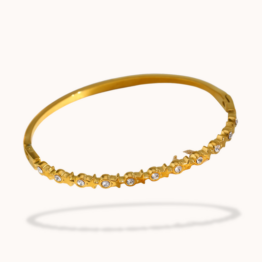 Gold bracelet with small diamonds on a white background