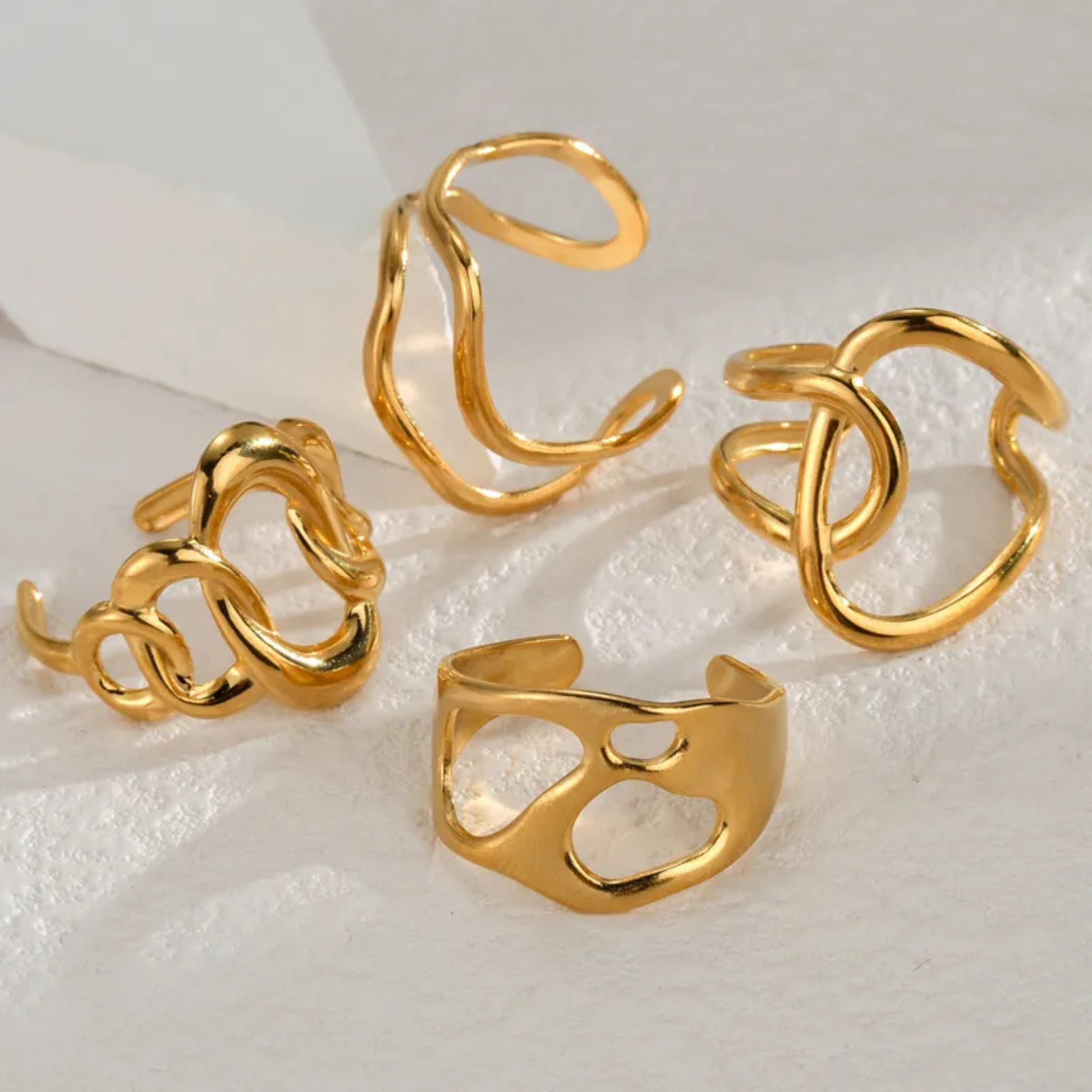 Set of gold rings on a textured white surface