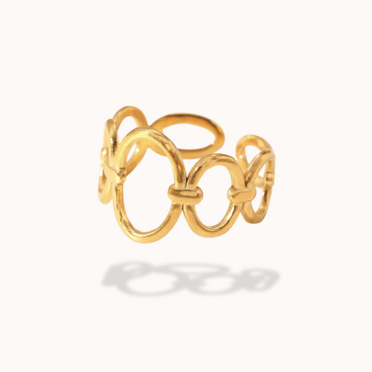 Gold ring with interlocking loops on a white background