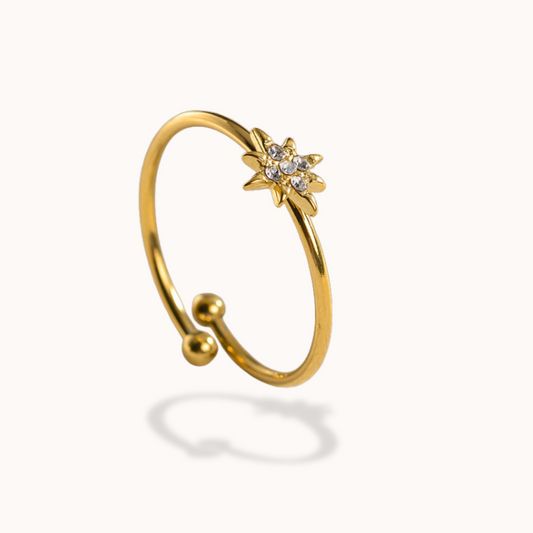 Gold ring with star design on a white background