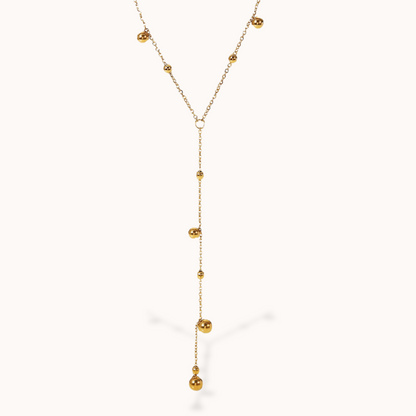 Gold necklace with small beads on a white background
