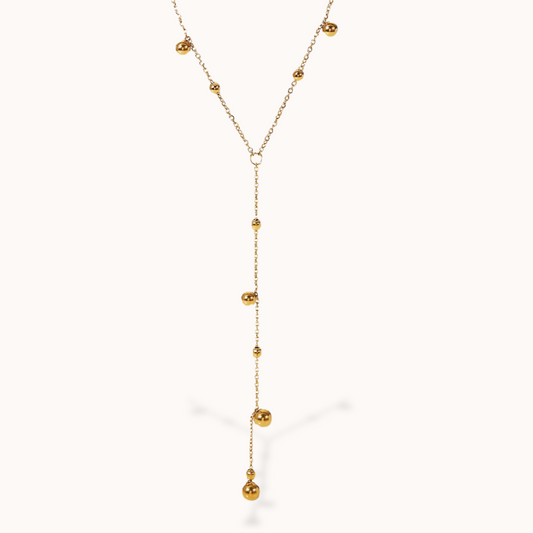 Gold necklace with small beads on a white background