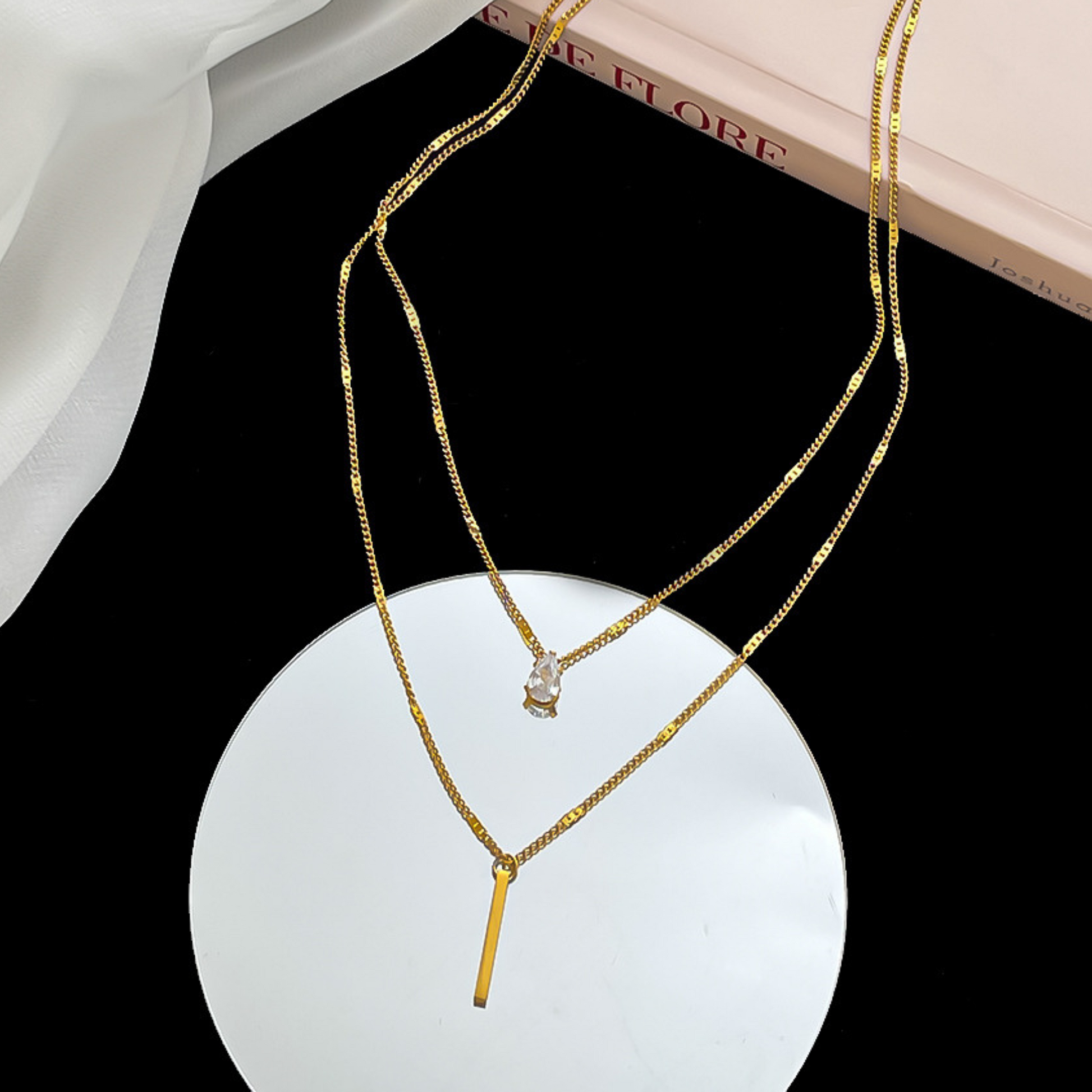 Gold necklace with a pendant on a black surface