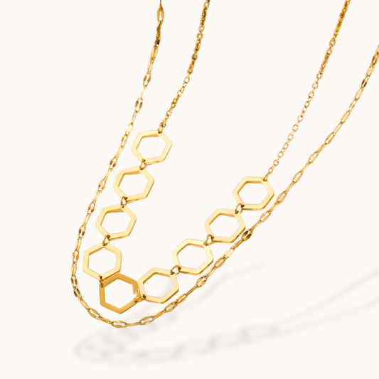 Gold hexagonal chain necklace on a white background
