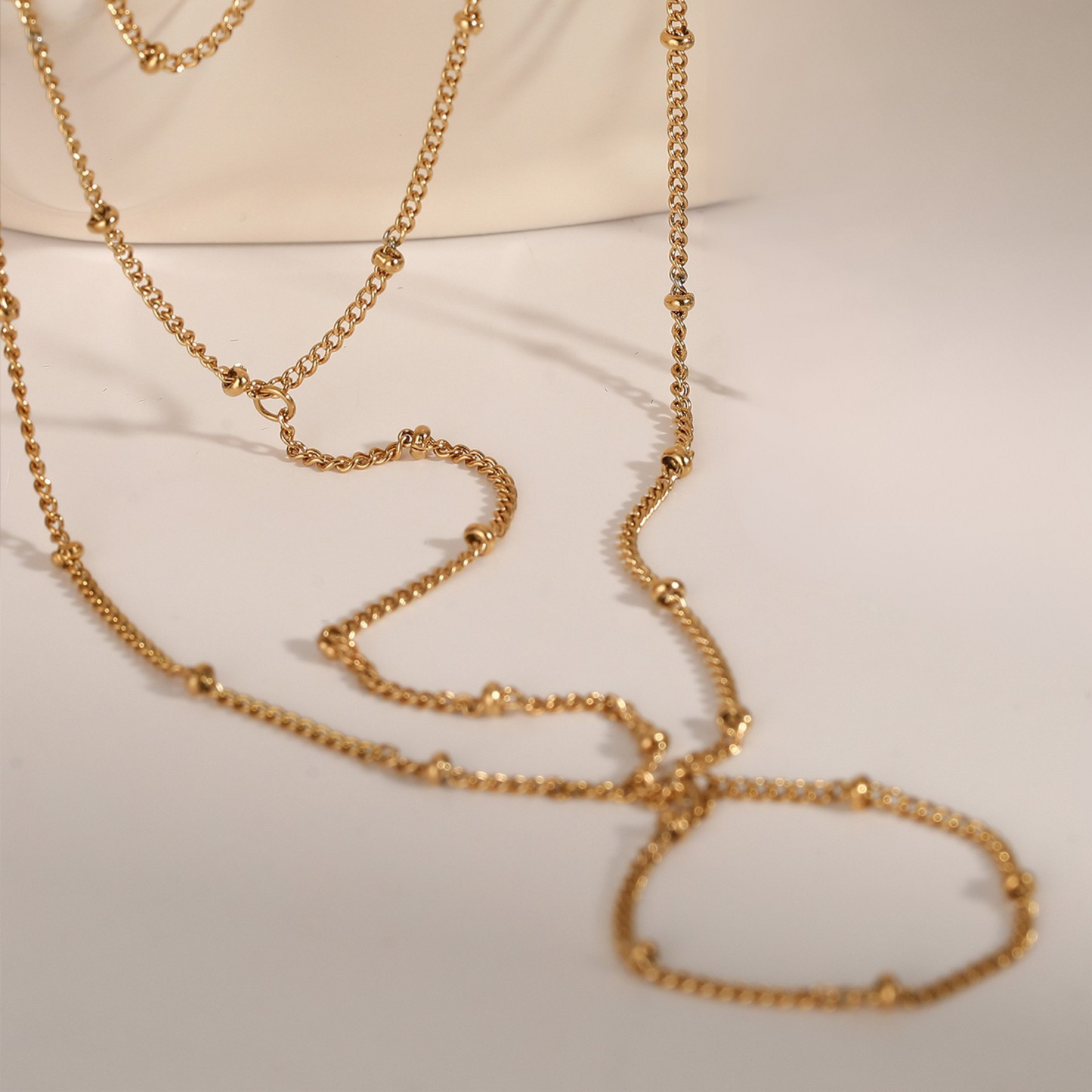 Gold ring chain bracelet on a light background