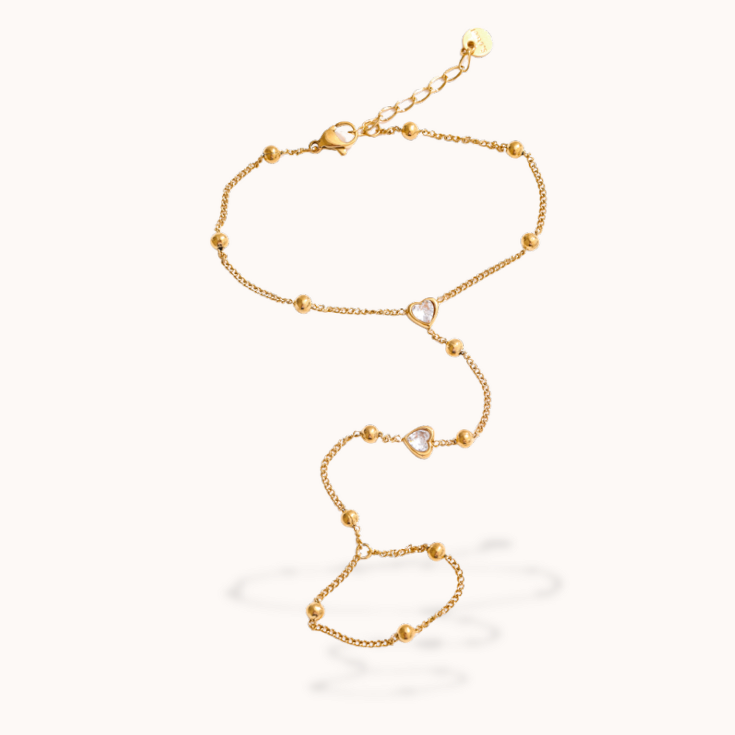 Gold ring bracelet with heart-shaped links on a white background