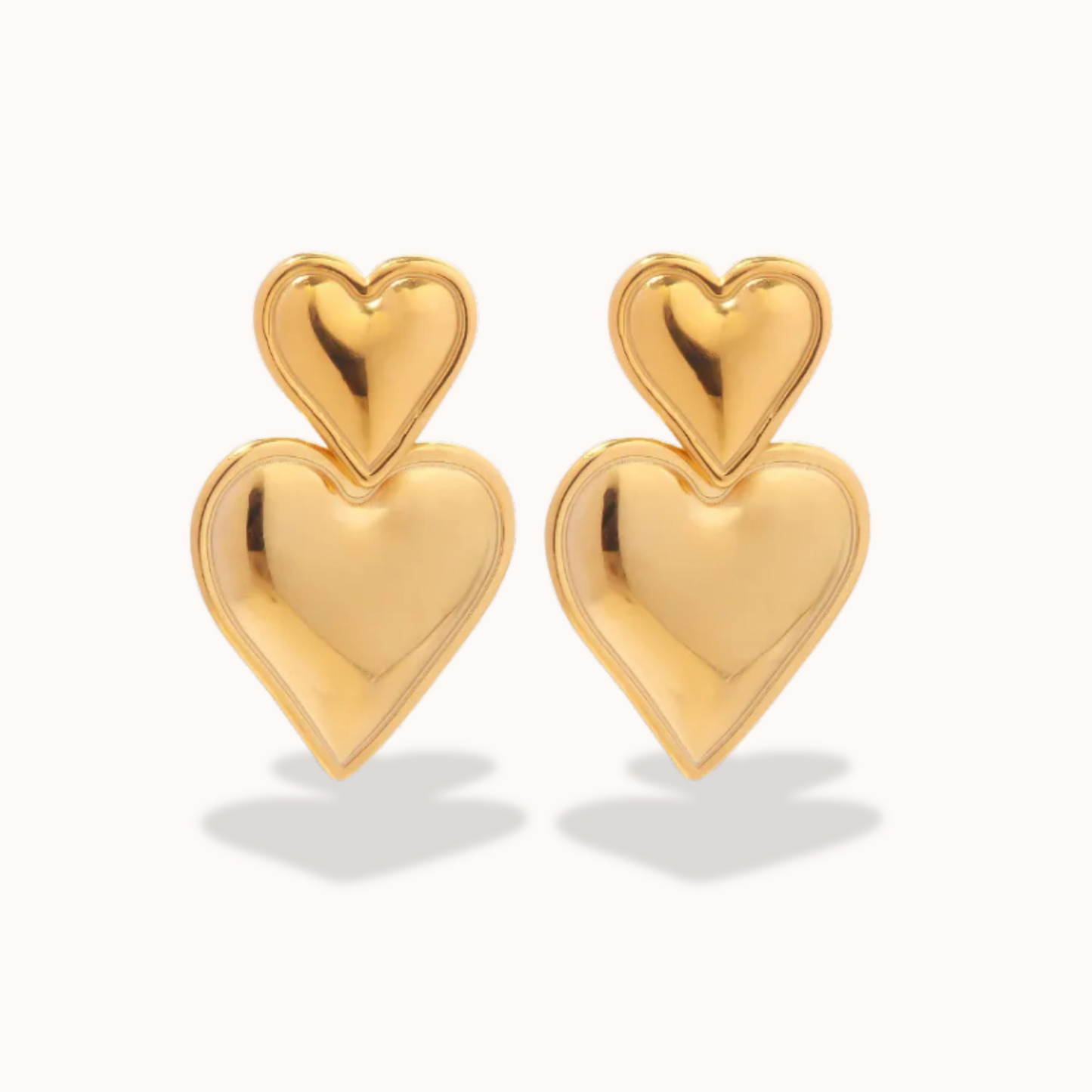 Gold heart-shaped earrings on a white background
