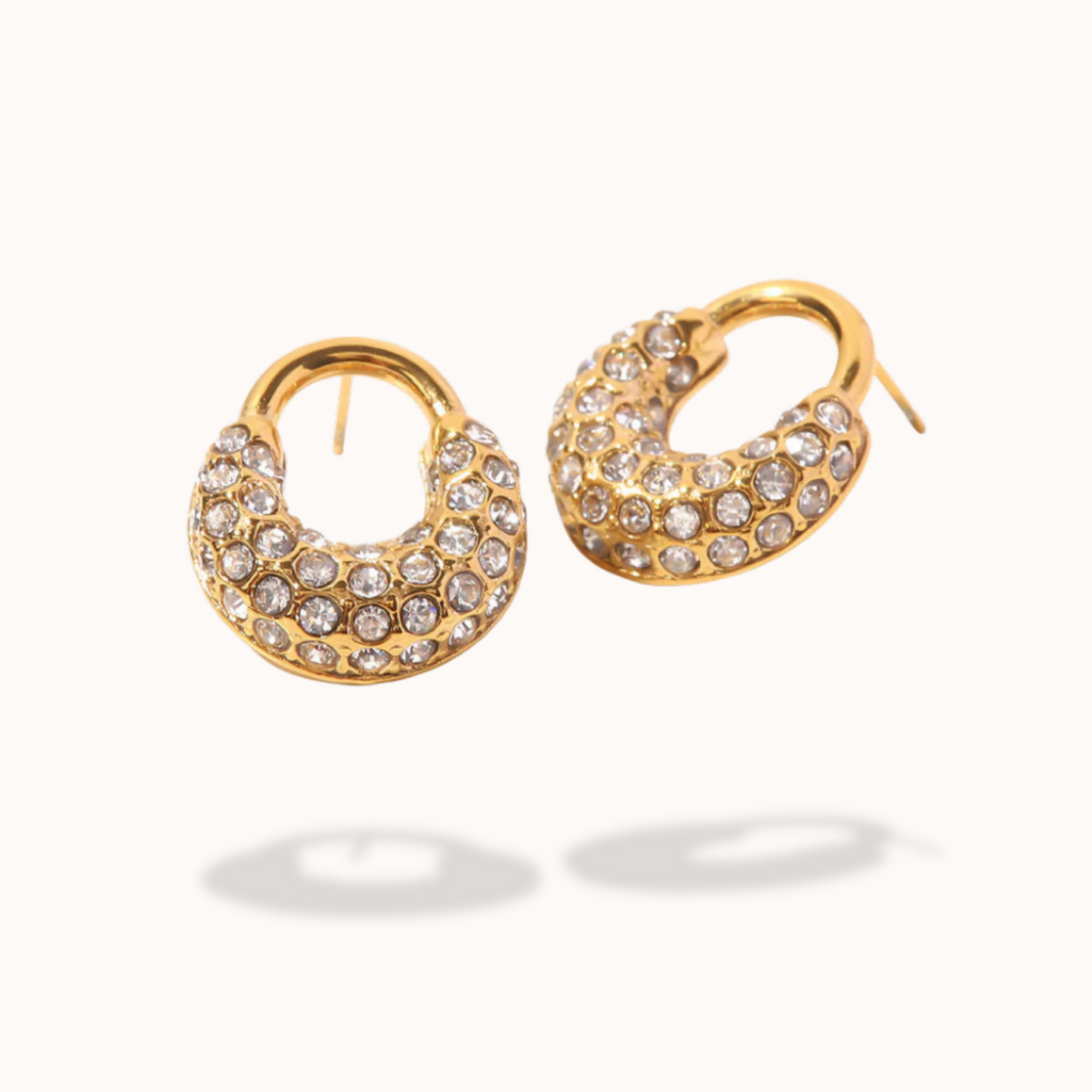 Gold hoop earrings with embedded crystals on a white background