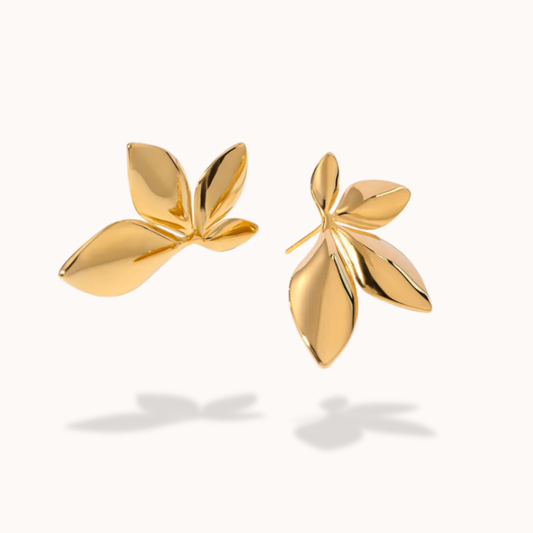 Gold leaf-shaped earrings on a white background