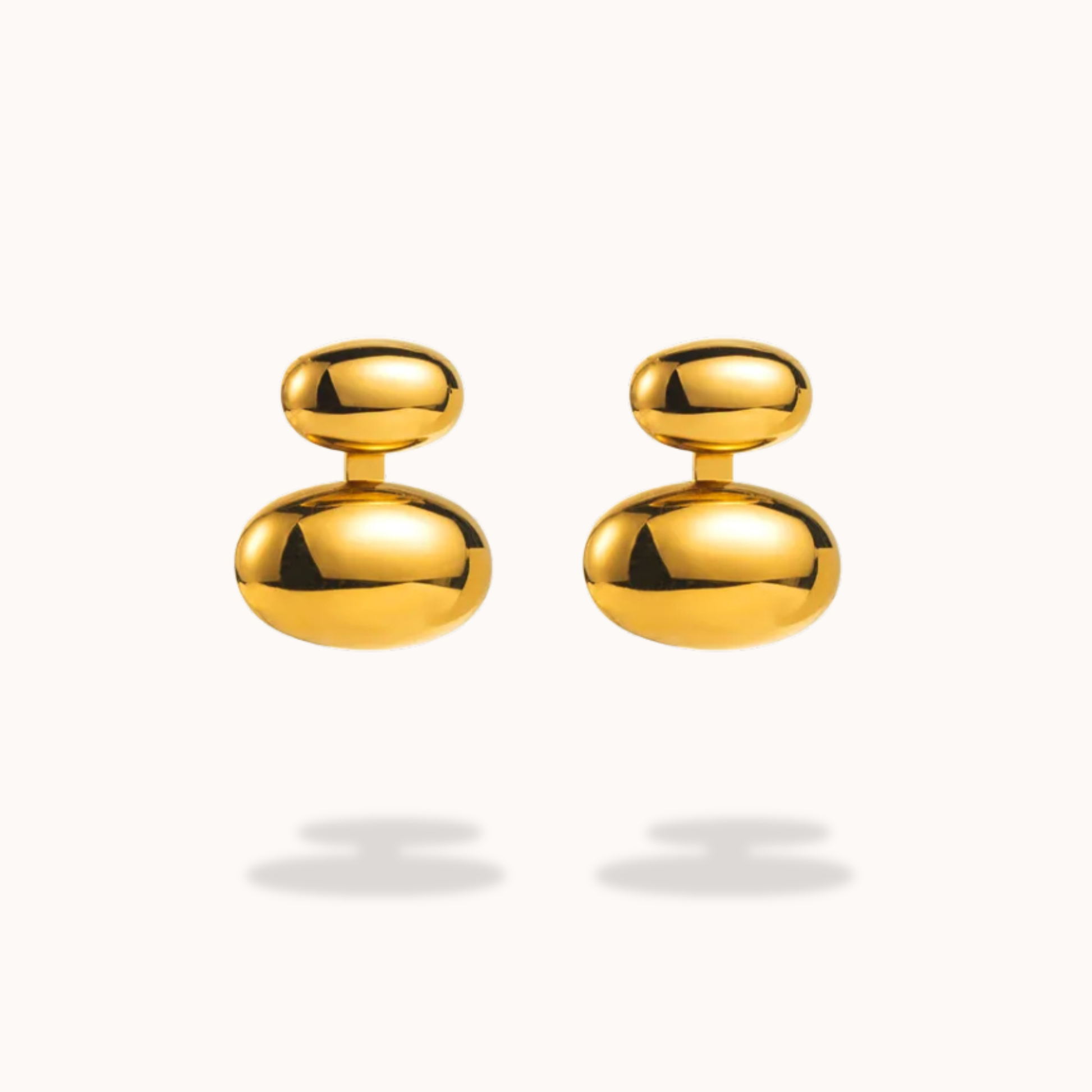 Pair of gold earrings on a light gray background
