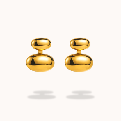 Pair of gold earrings on a light gray background