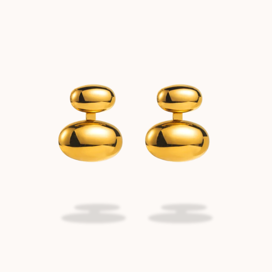 Pair of gold earrings on a light gray background