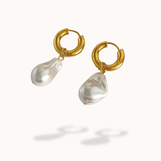 Gold hoop earrings with teardrop-shaped pearls on a white background