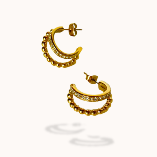 Gold hoop earrings with embedded stones on a white background