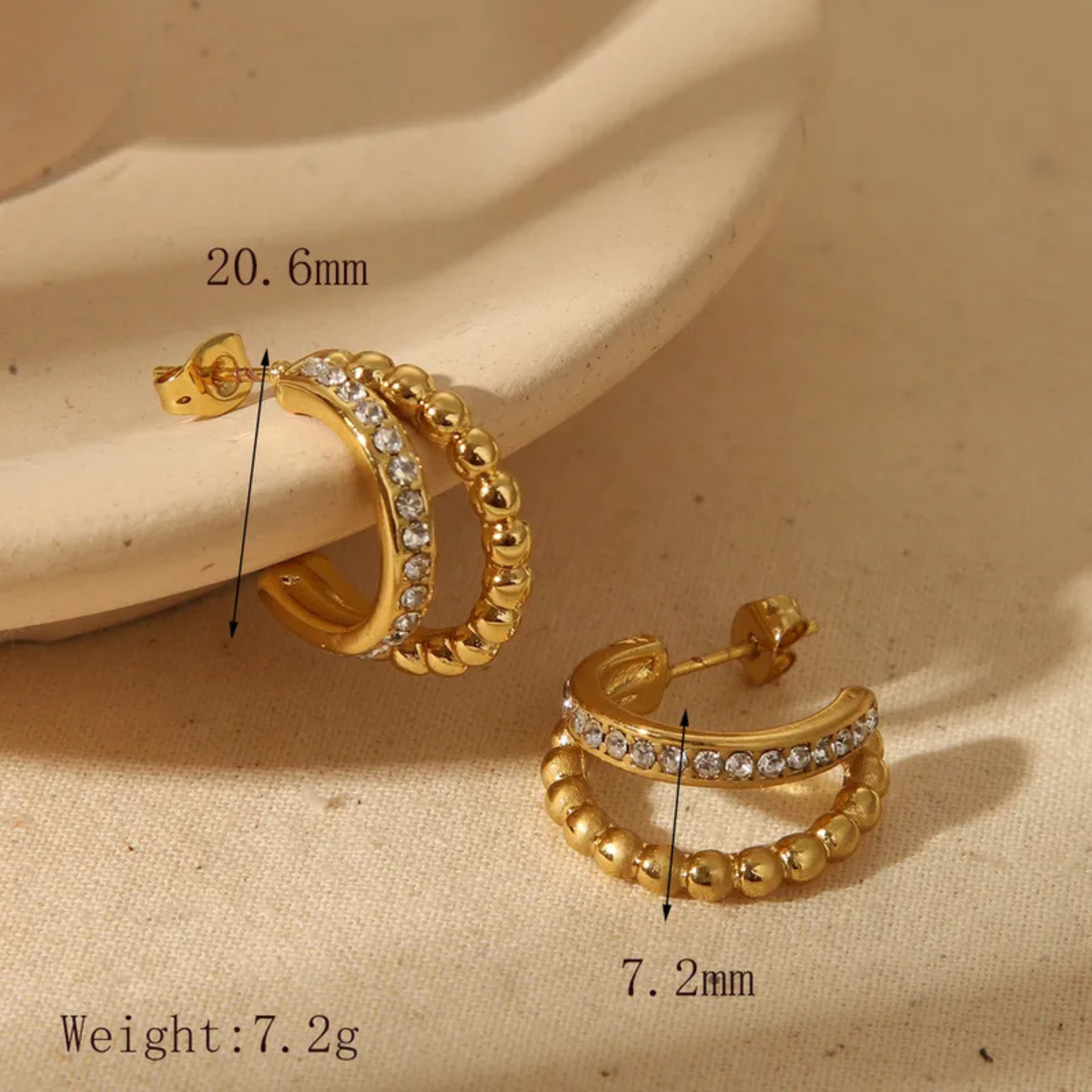 Gold hoop stud earrings with measurements and weight on a beige background