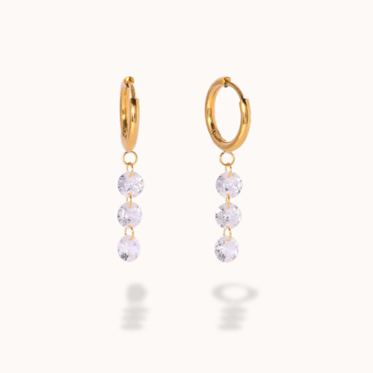 Gold hoop earrings with clear gemstones on a white background