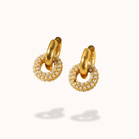 Gold hoop earrings with pearl-like embellishments on a white background