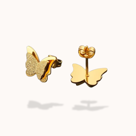 Gold butterfly-shaped earrings on a white background