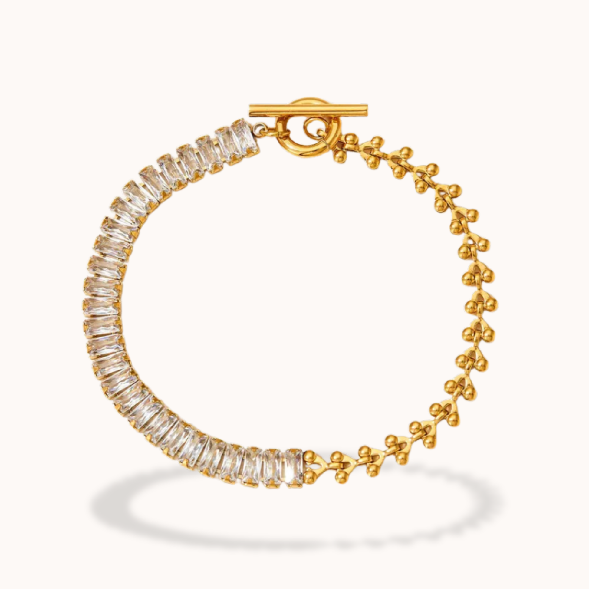 Gold bracelet with clear gemstones on a white background