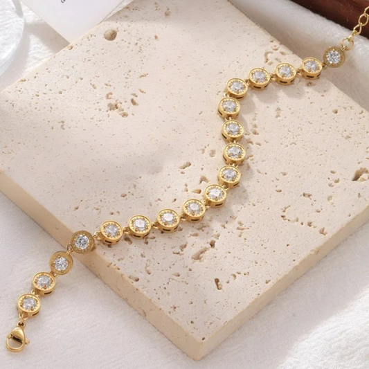 Gold bracelet with diamonds on a textured beige surface