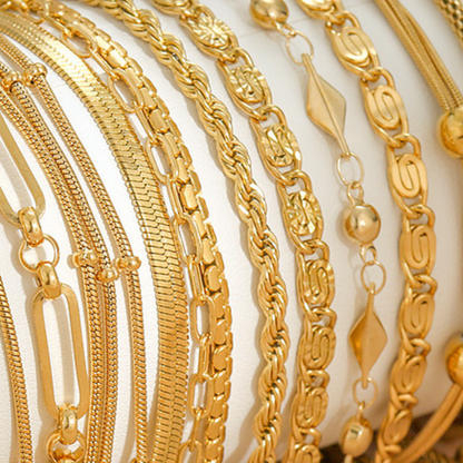 Collection of gold chains on a light background