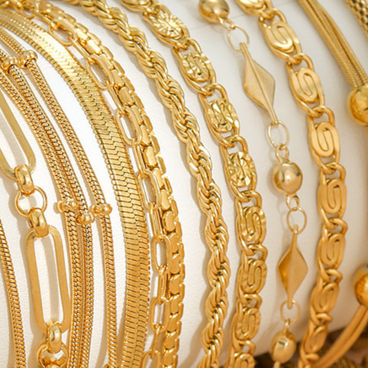 Collection of gold chains on a light background
