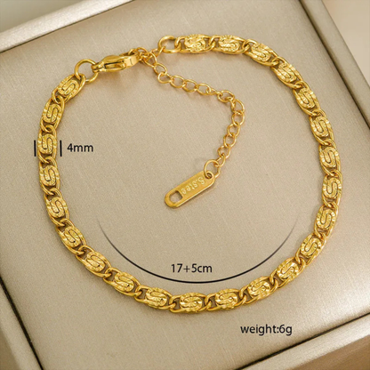 Gold bracelet with measurements on a beige background