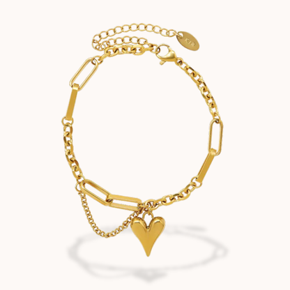Gold bracelet with a heart charm on a white background