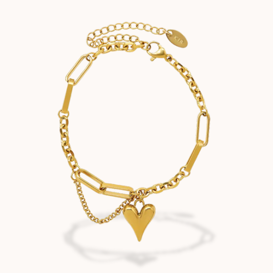 Gold bracelet with a heart charm on a white background