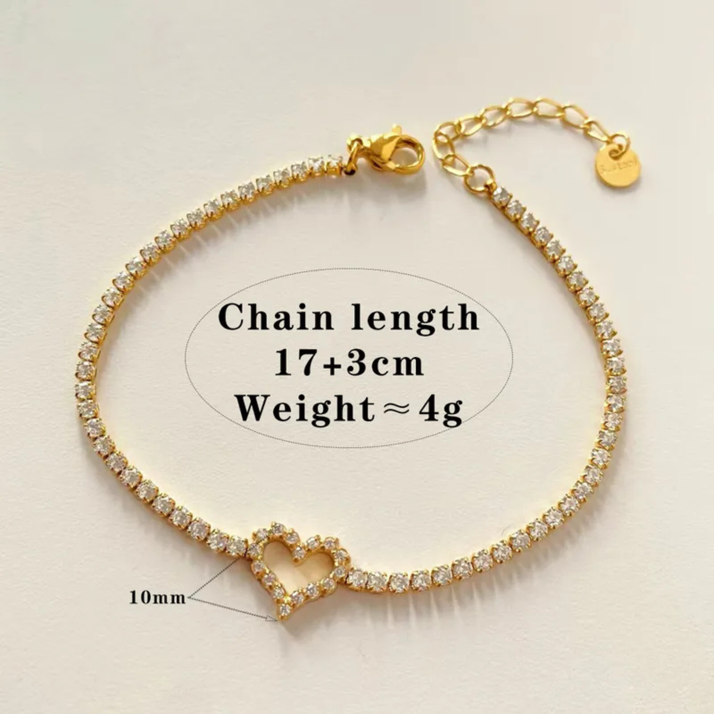 Gold bracelet with heart charm on a beige background