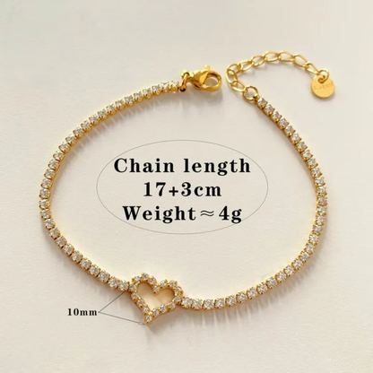 Gold bracelet with heart charm on a beige background