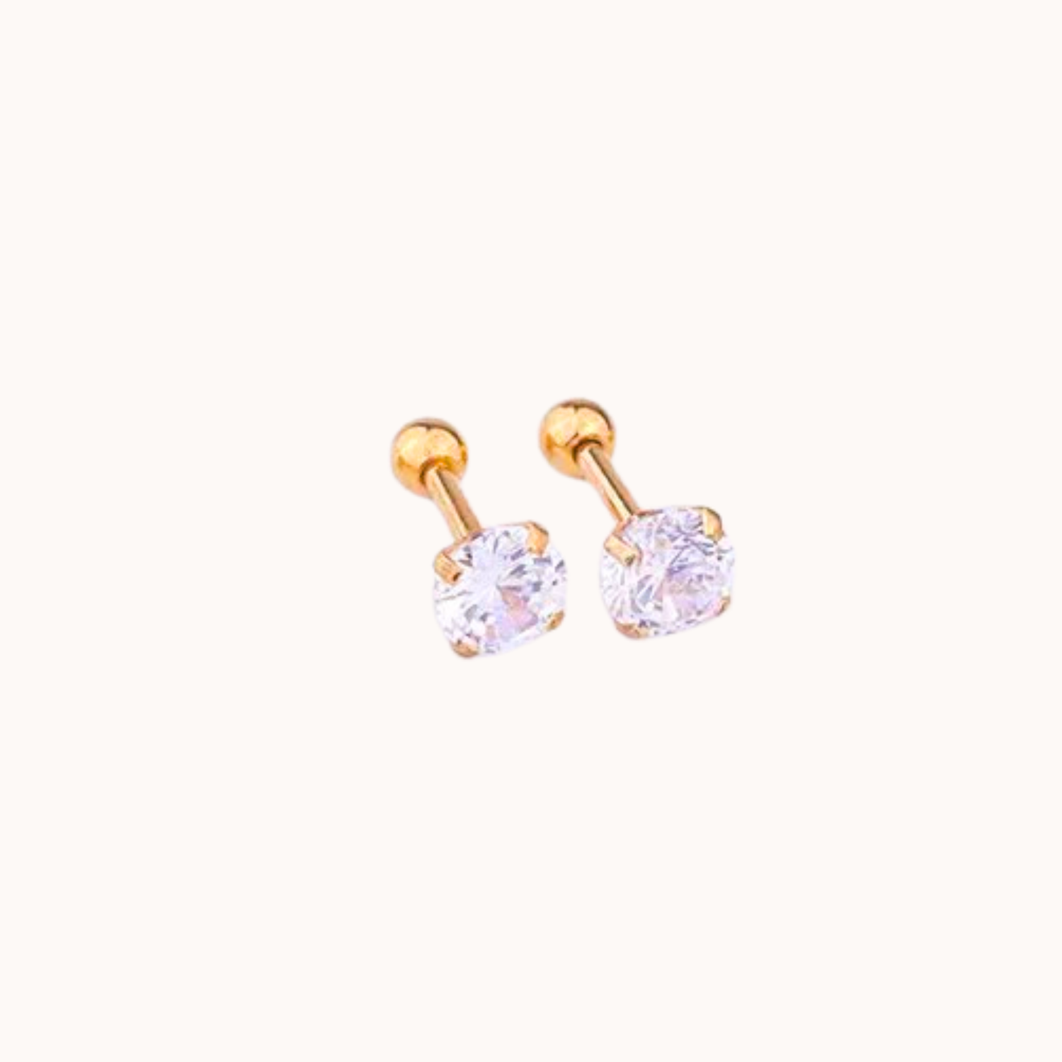 Pair of gold earrings with clear gemstones on a white background