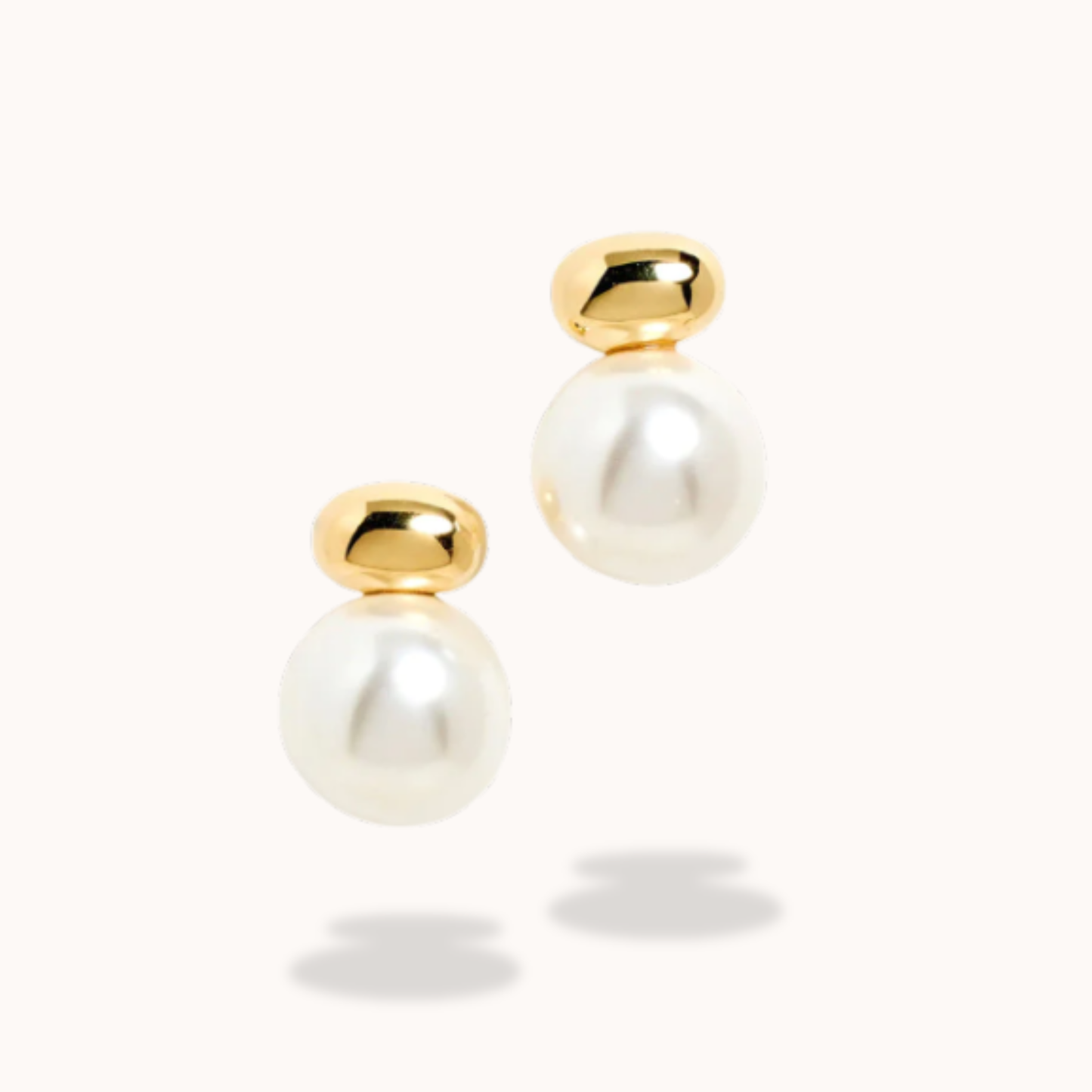 Pair of pearl earrings with gold tops on a white background