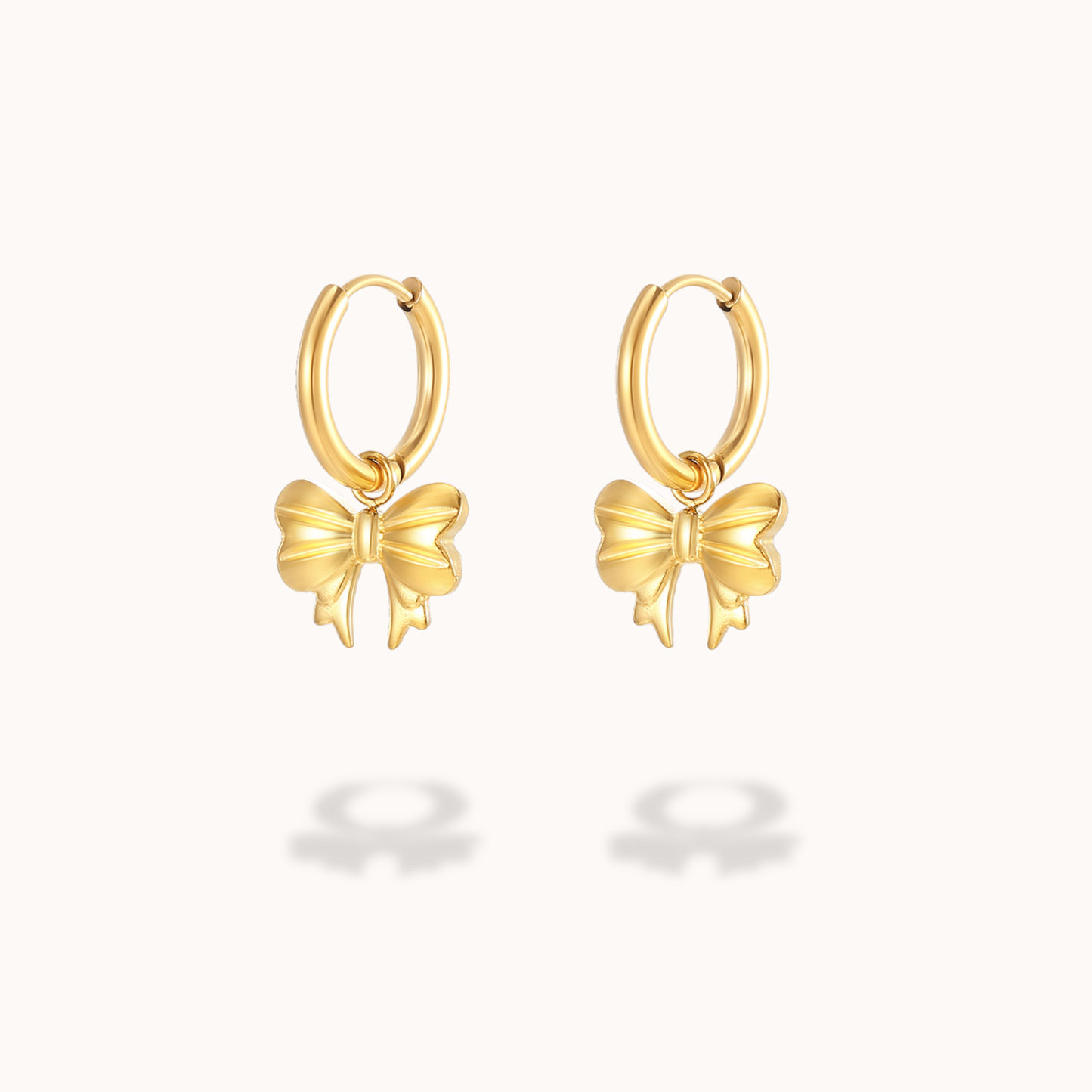 Gold bow-shaped hoop earrings on a white background