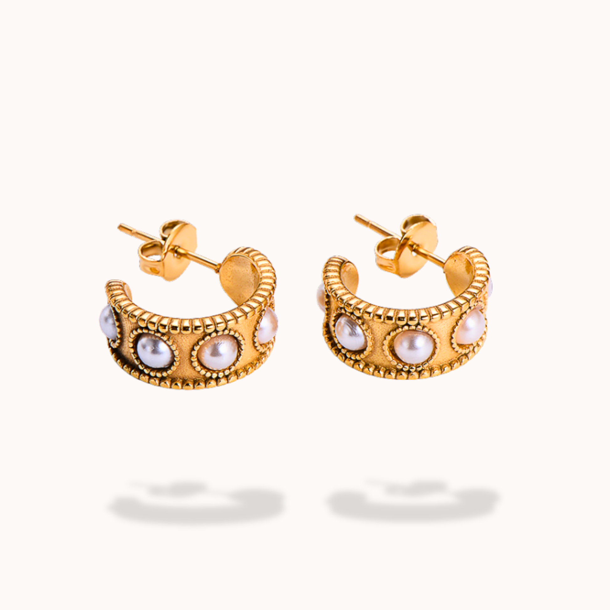 Gold hoop earrings with pearl-like stones on a white background