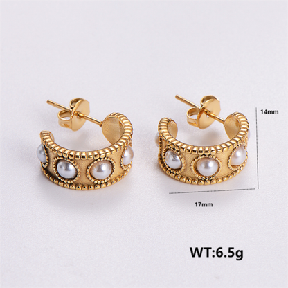 Gold hoop earrings with pearls on a white background